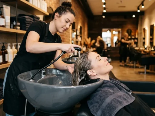 Woman relaxing during professional hair wash at modern salon with ceramic sink and premium products